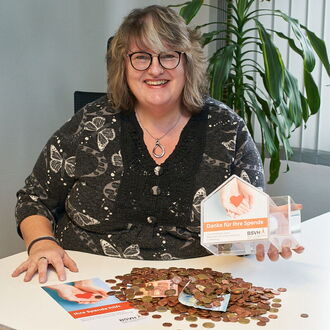 Lydia Wiebalk, zuständig für das Spendenmanagement im BSVH, an ihrem Schreibtisch. Sie hat gerade ein Spendenhaus ausgeleert, das Geld liegt vor ihr auf dem Tisch.