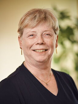 Jutta Schaaf hat kurgeschnittenes blondes Haar mit rötlichen Strähnen. Sie lächelt in die Kamera. Gekleidet ist sie mit einem schwarzen Oberteil mit einem V-Ausschnitt