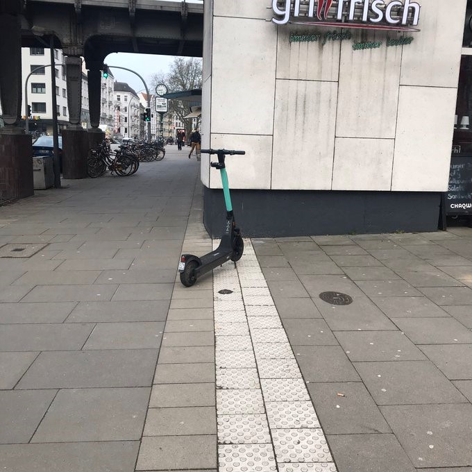 Das Bild zeigt einen E-Scooter, der quer auf dem Leitstreifen abgestellt wurde.